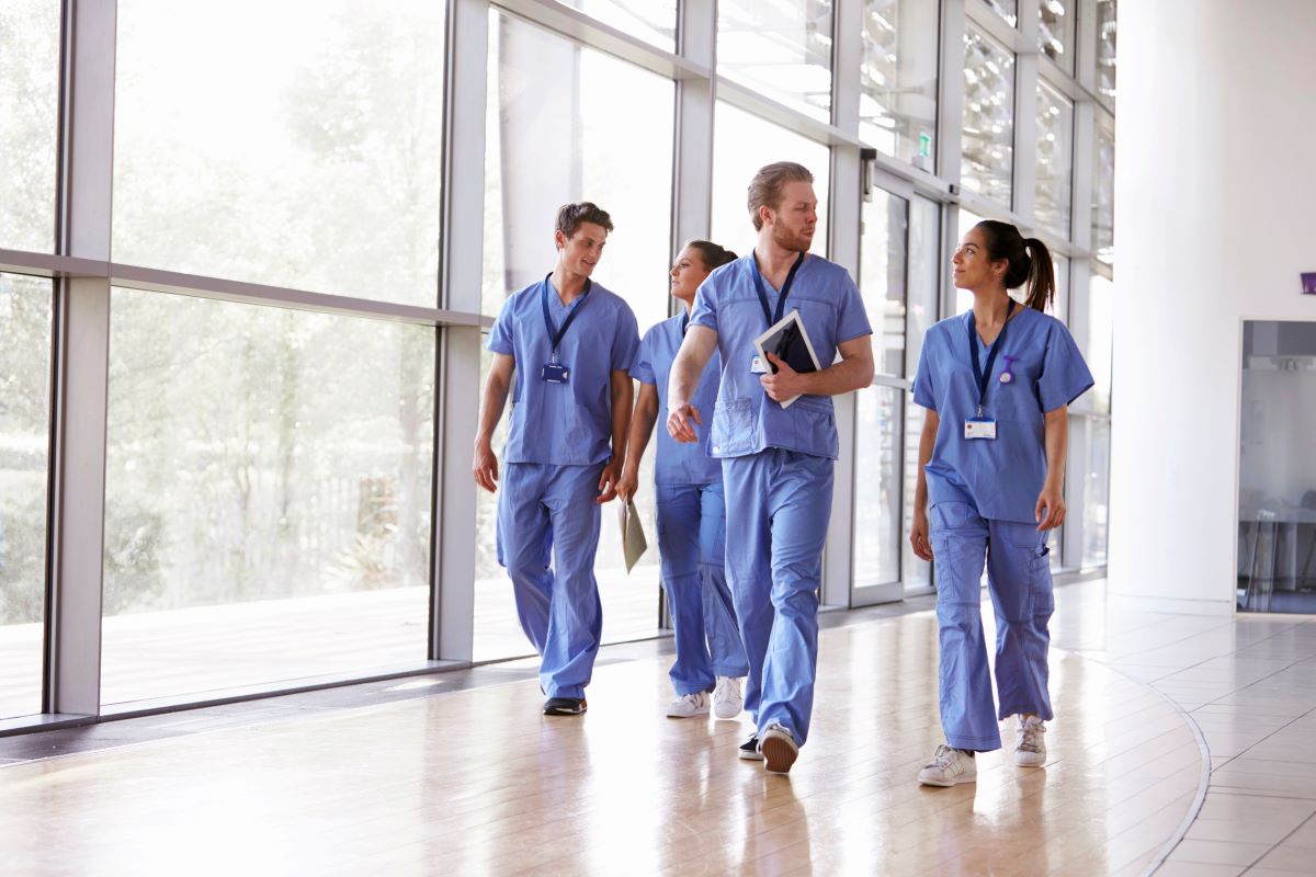 Nursing management team walking together in lobby of facility