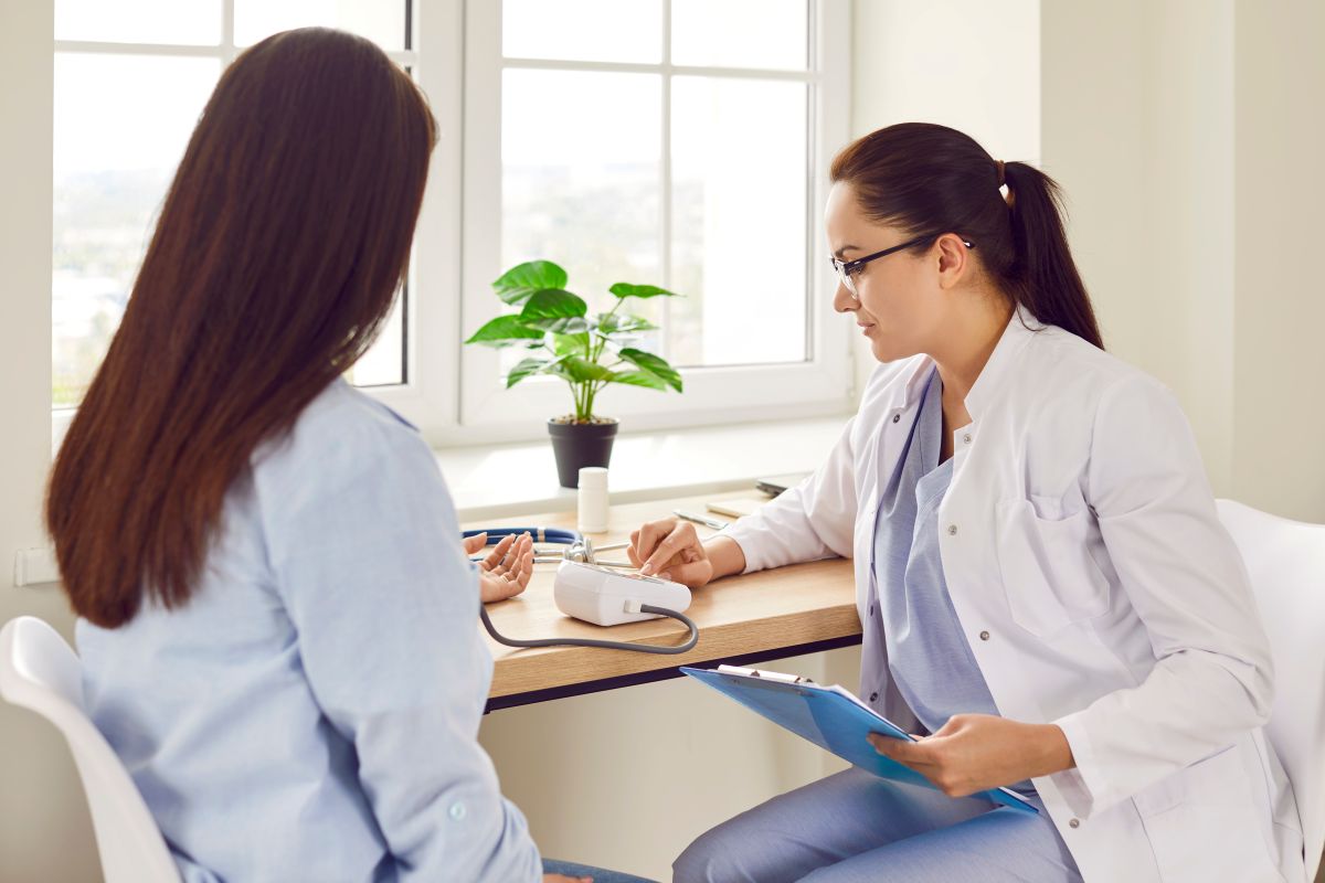 An OB-GYN nurse checks the blood pressure of one of her patients.