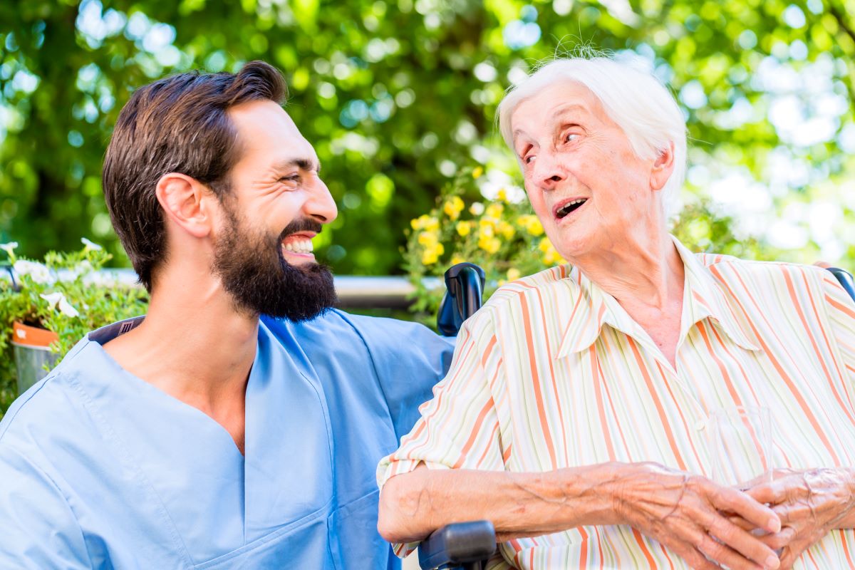 A nurse assistant has a conversation with one of his patients.