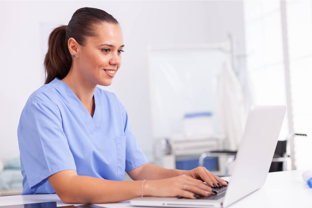 A nurse logs patient data while keeping patient privacy in mind.