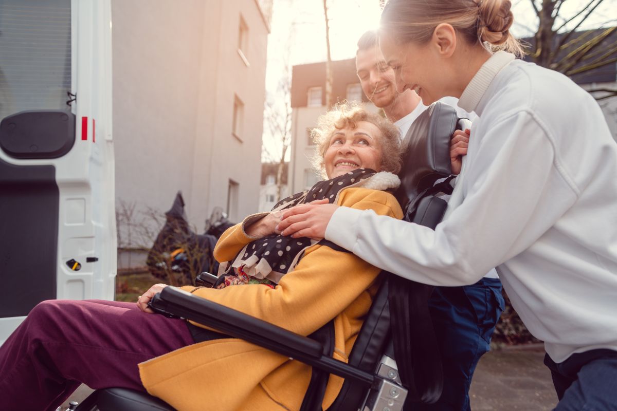 A patient transporter helps move a patient via wheelchair and van.