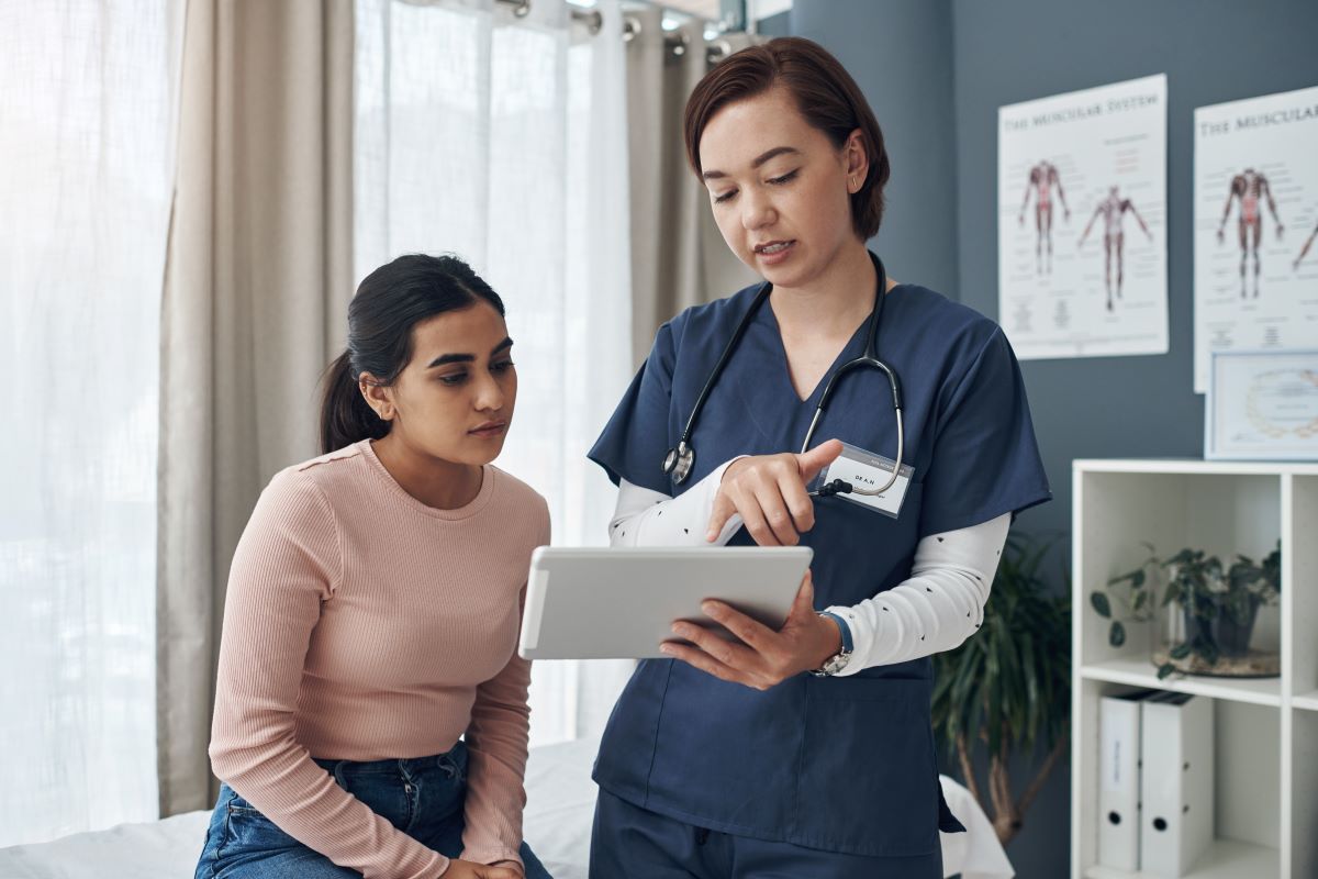 A CNA, using a point of care device, updates a patient's chart.