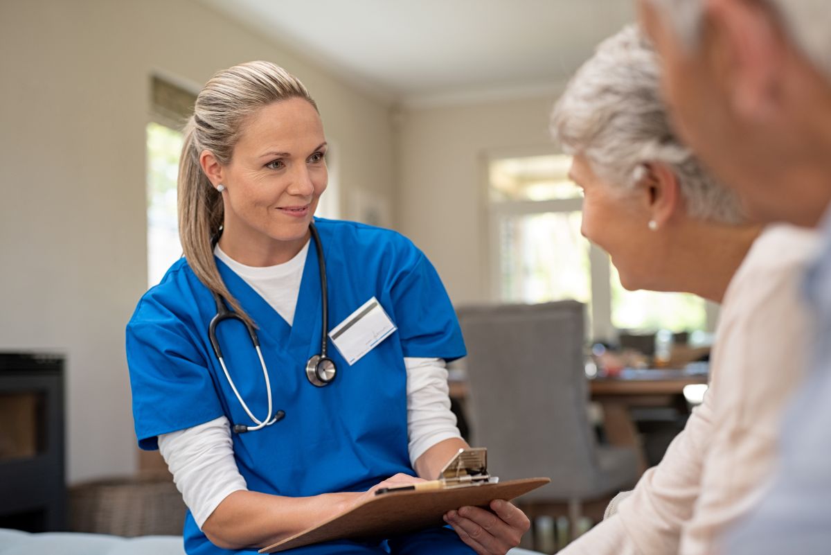 A nurse meets with her patient and their spouse.