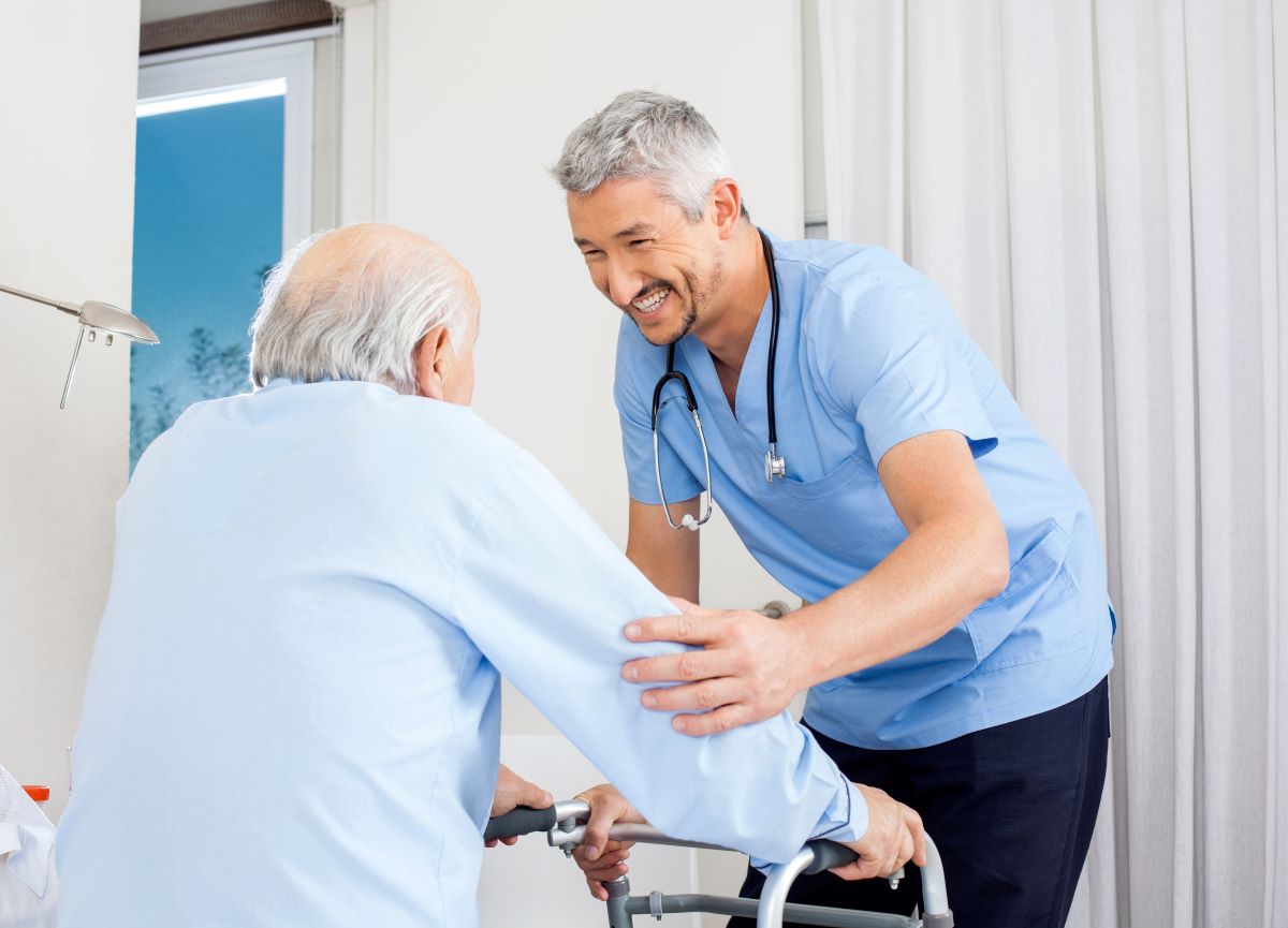 A nurse helps a nursing home resident who's at a high risk for falls use his walker.