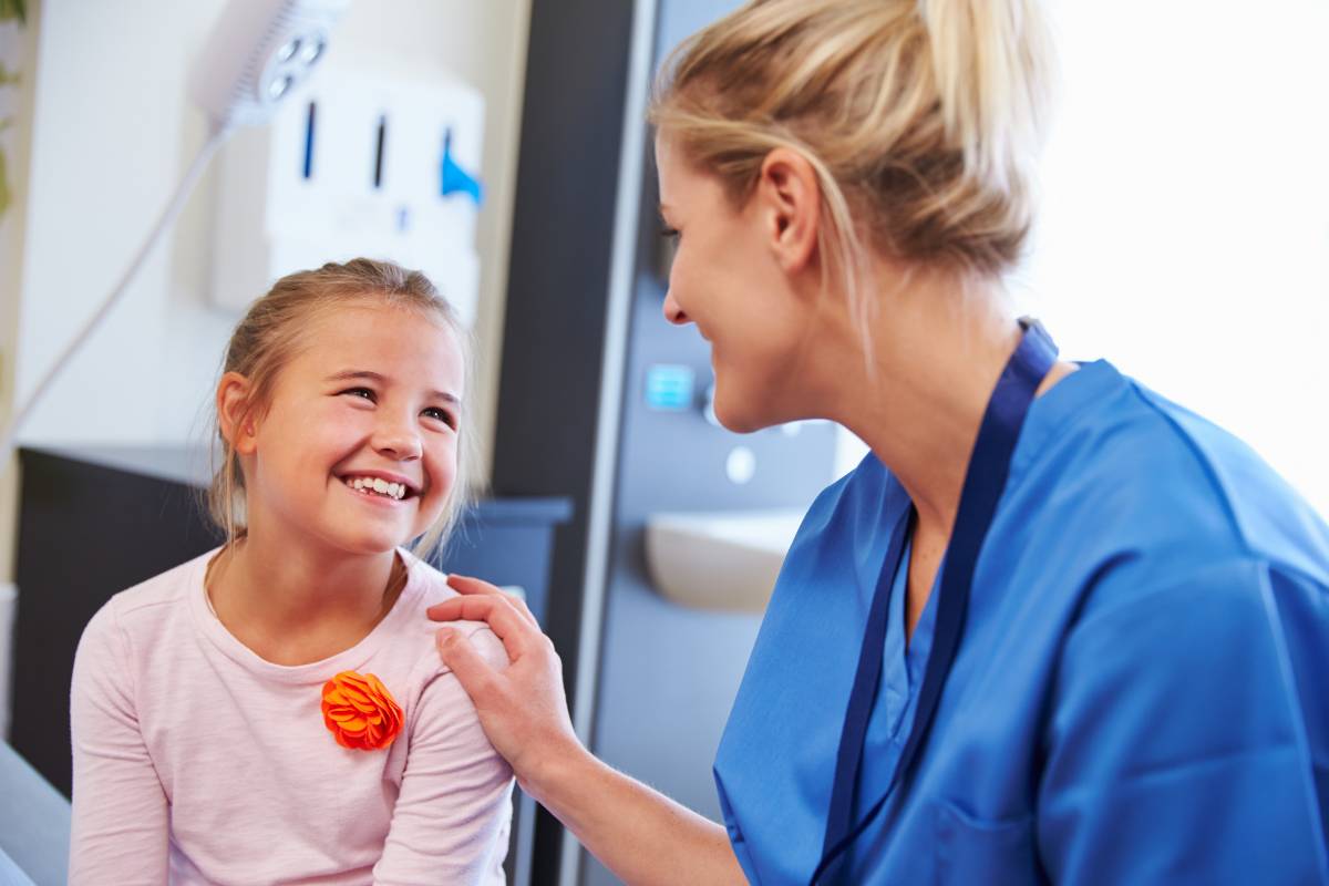 A nurse works with a student after using her school nurse resume to get a job.