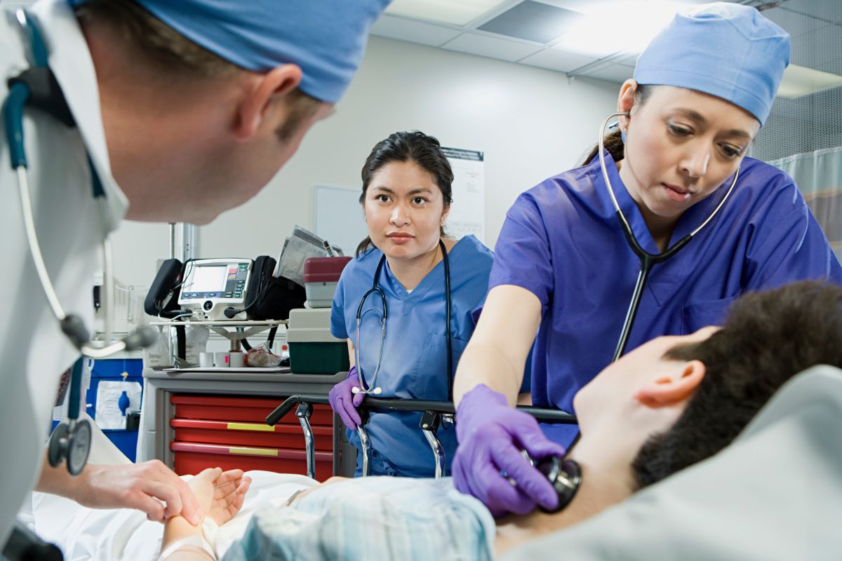 Two SICU nurses check on a patient after surgery.