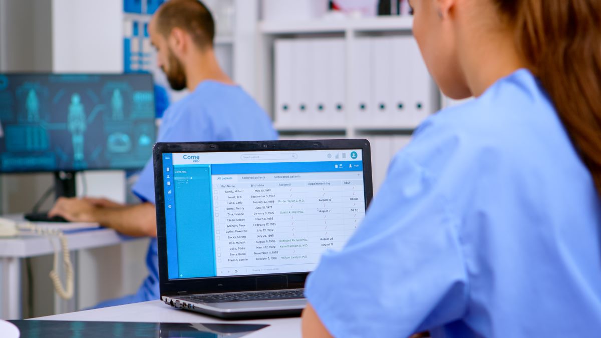 A nurse looks up source-oriented medical records on a laptop computer.