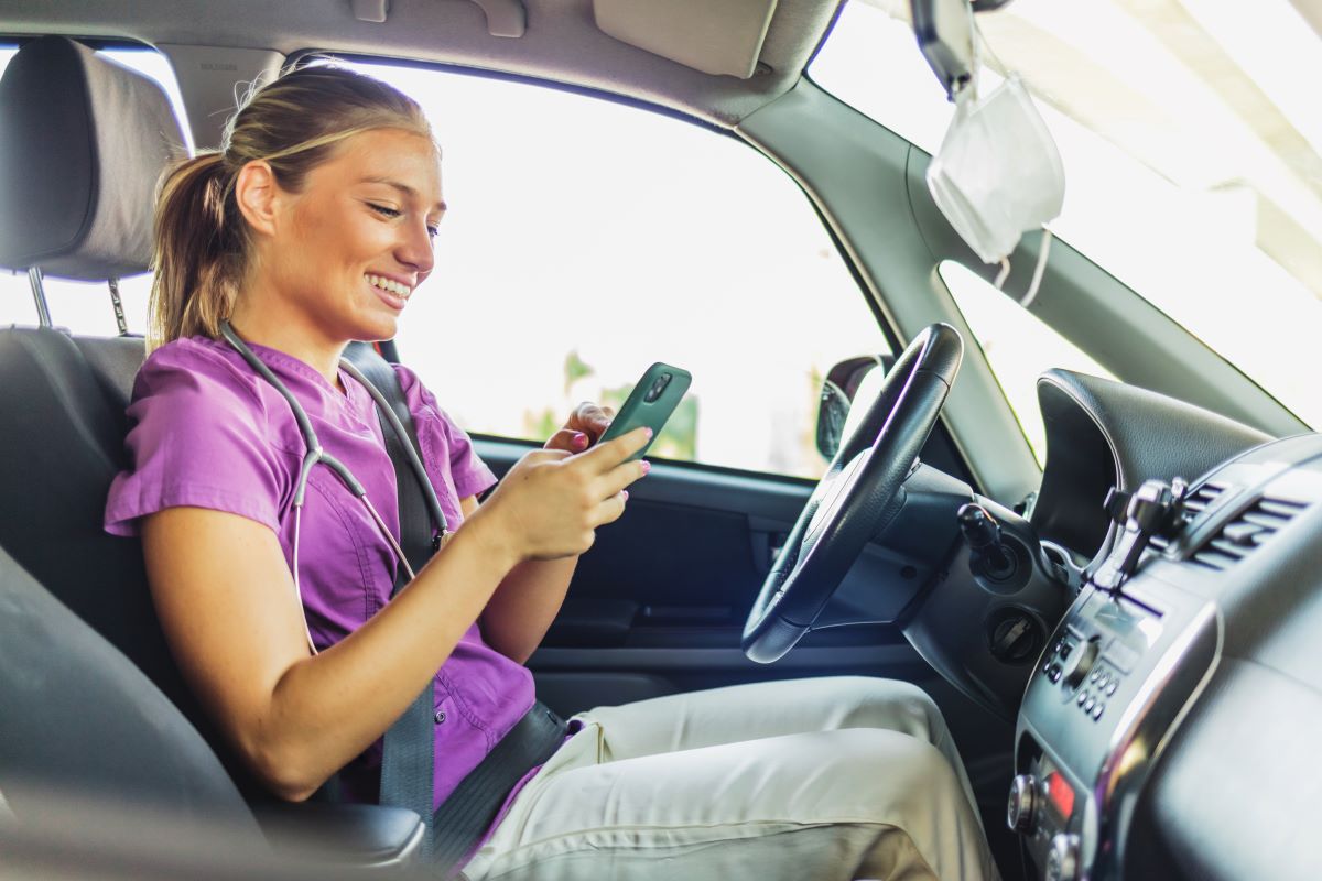 A travel nurse checks for directions on her mobile phone as she travels to a client's location.