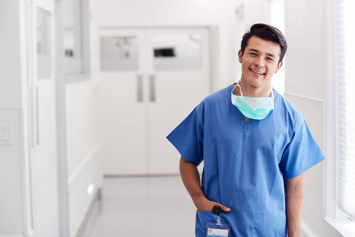 A urology nurse stands in a hospital corridor.