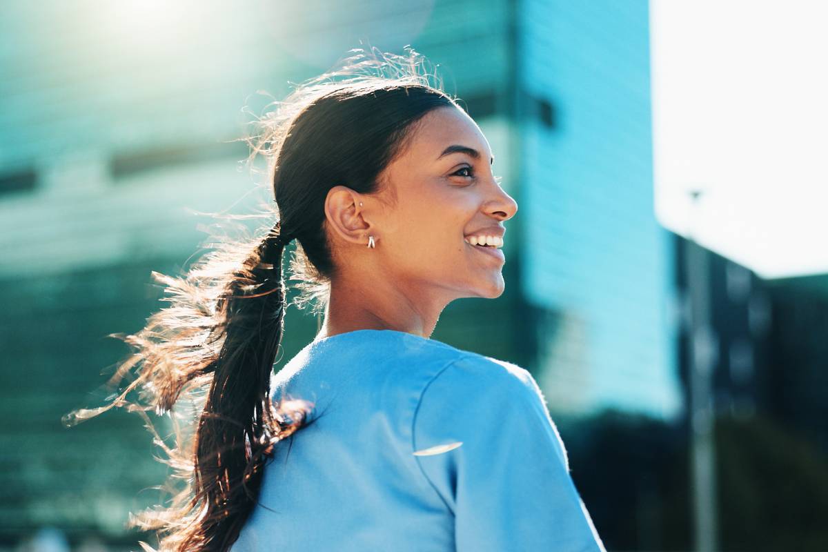 A nurse smiles during a break outside while discussing the best words to describe a nurse.